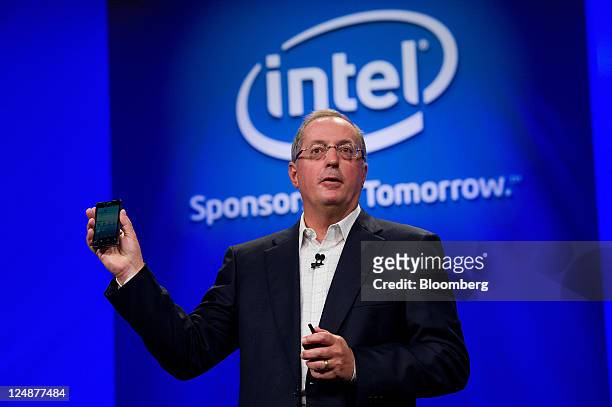 Paul Otellini, president and chief executive officer of Intel Corp., holds a Google Android phone that uses an Intel chip as he delivers his keynote...