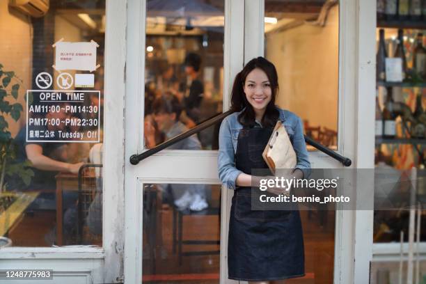 woman at small business entrance - taiwan business stock pictures, royalty-free photos & images