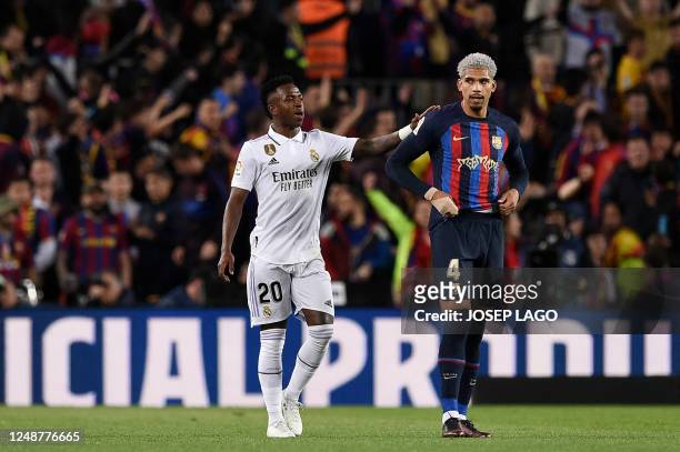 Real Madrid's Brazilian forward Vinicius Junior greets Barcelona's Uruguayan defender Ronald Araujo after he scored an own goal during the Spanish...