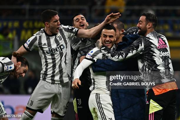 Juventus' Serbian midfielder Filip Kostic celebrates with Juventus' French midfielder Adrien Rabiot and Juventus' Serbian forward Dusan Vlahovic...