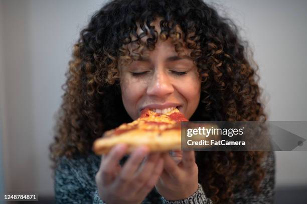 black woman eating pizza by herself - eating pizza stock pictures, royalty-free photos & images