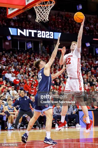 Wisconsin forward Steven Crowl goes left handed over Liberty forward Zach Cleveland during a second round National Invitational Tournament college...
