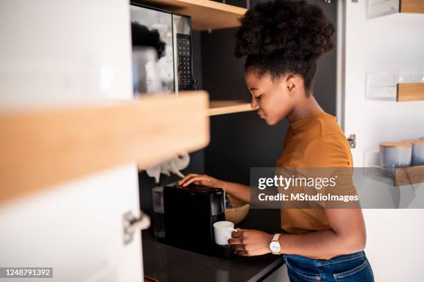 donna che prepara un caffè fresco con una macchina per la caffettiera - caffettiera foto e immagini stock