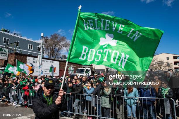 Person waves a "Believe in Boston" flag during the South Boston St. Patrick's Day/Evacuation Day Parade in Boston, Massachusetts on March 19, 2023. -...