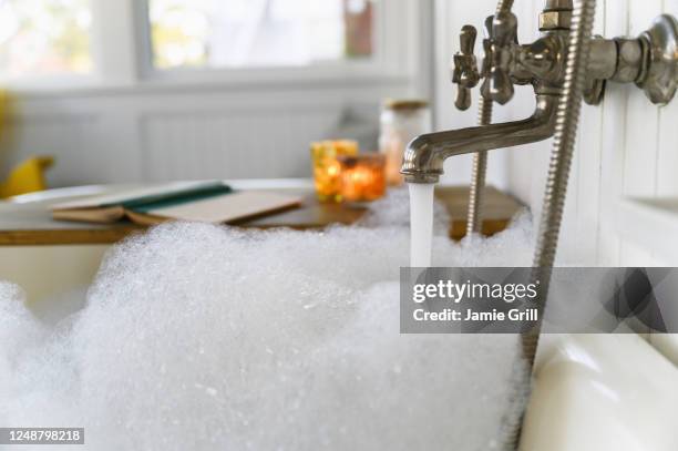 bubble bath with book and candles - bubble bath foto e immagini stock