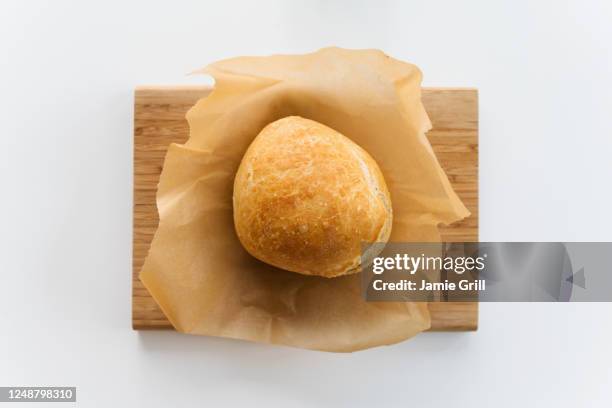 fresh loaf of bread cooling on cutting board - backpapier stock-fotos und bilder