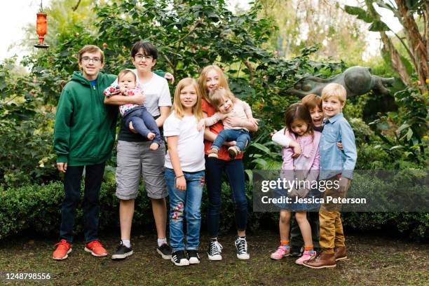 usa, california, orange county, group of children (12-17 months, 2-3, 6-7, 10-11, 12-13, 14-15) posing in garden - cousins stock-fotos und bilder