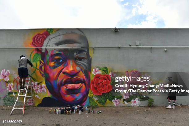 Artists "Detour" Thomas Evans, left, and "Hiero" are creating mural of George Floyd near the corner of High St. And E. Colfax Ave. In Denver,...