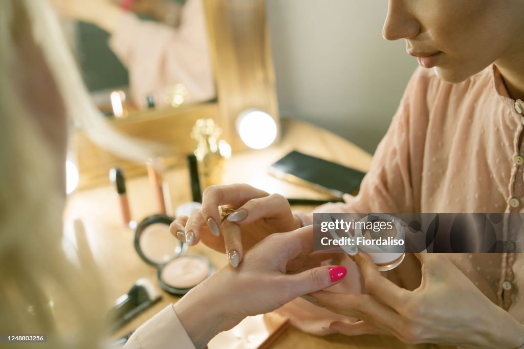 Young girl doing make up to a woman