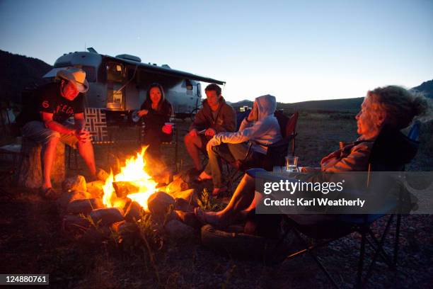 sitting by campfire - fogueira de acampamento imagens e fotografias de stock