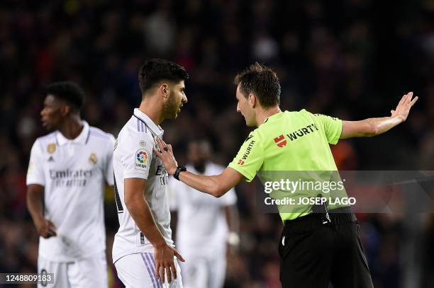 Spanish referee Ricardo De Burgos Bengoetxea talks to Real Madrid's Spanish midfielder Marco Asensio after annulling his goal following a VAR...