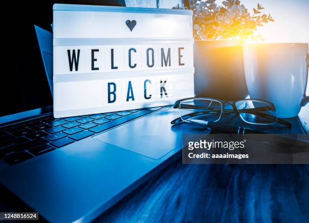 welcome back showed on light box at workspace - dorsale foto e immagini stock