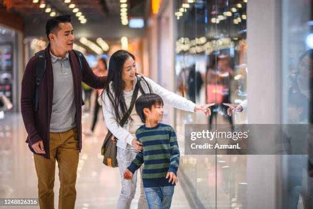 chinese mother showing son retail display at hong kong mall - chinese young adults shopping imagens e fotografias de stock