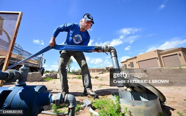 John Hornewer delivers water from his truck to a residential water tank in Rio Verde Foothills, Arizona, on February 23, 2023. - Homes in...