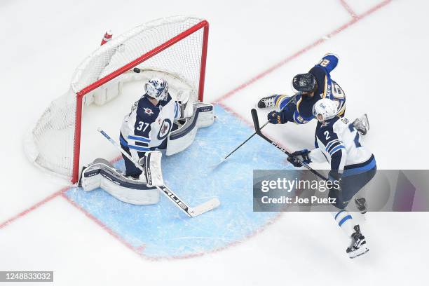 Nathan Walker of the St. Louis Blues scores a goal past Connor Hellebuyck of the Winnipeg Jets at the Enterprise Center on March 19, 2023 in St....