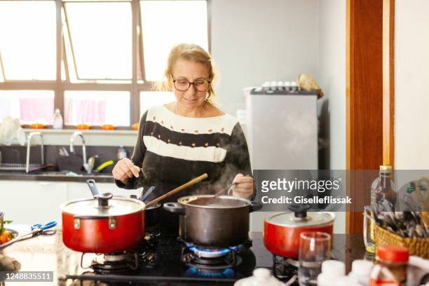 mulher cozinhando e preparando almoço na cozinha - homemaker - fotografias e filmes do acervo