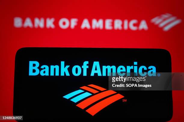 In this photo illustration, a Bank of America Corporation logo is seen on a smartphone and in the background.