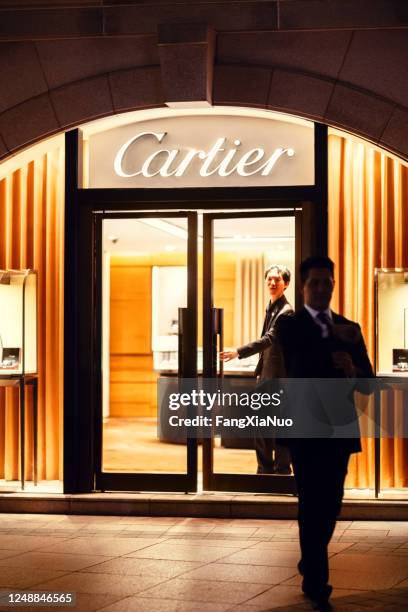 businessman walking out cartier store at night, doorman holds door, hong kong - sports event security stock pictures, royalty-free photos & images