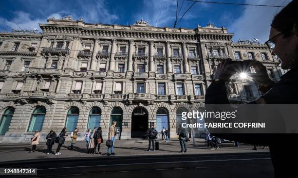 Man takes a picture of the Credit Suisse headquarters after Swiss bank giant UBS has agreed to take over its troubled Swiss rival, in Zurich on March...