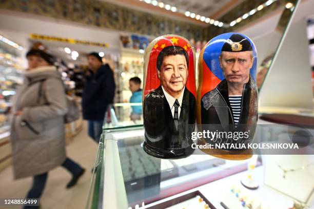 This picture taken on March 20, 2023 shows traditional Russian wooden nesting dolls, called Matryoshka dolls, depicting Chinese President Xi Jinping...