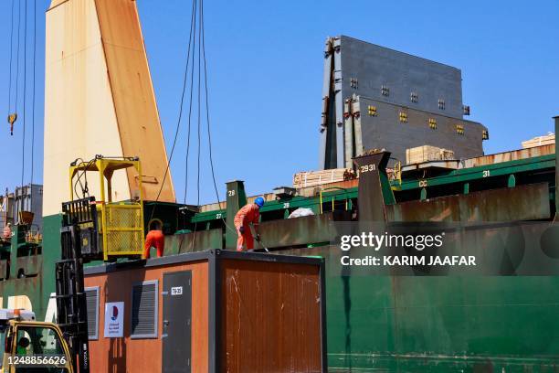 Workers load cabins and caravans used during the football World Cup in Qatar onto a cargo ship slated for departure from Hamad Port, on March 20 as a...