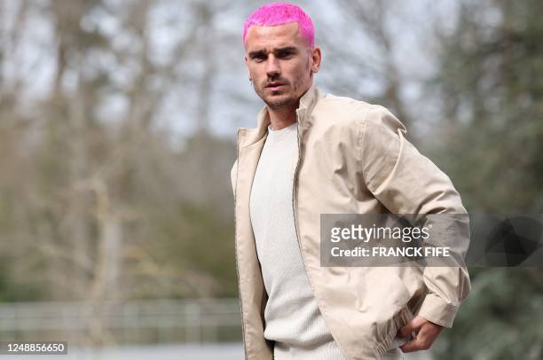 France's forward Antoine Griezmann supporting pink hair arrives in Clairefontaine-en-Yvelines on March 20, 2023 as part of the team's preparation for...