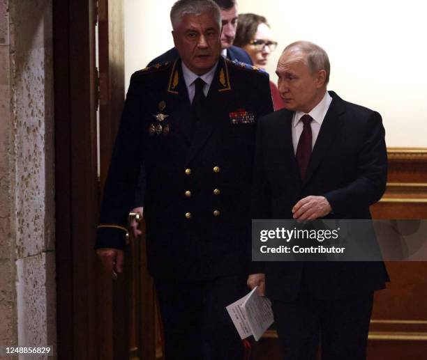 Russian President Vladimir Putin and Interior Minister Vladimir Kolokoltsev enter the hall during the Expanded Board Meeting at the Interior Ministry...