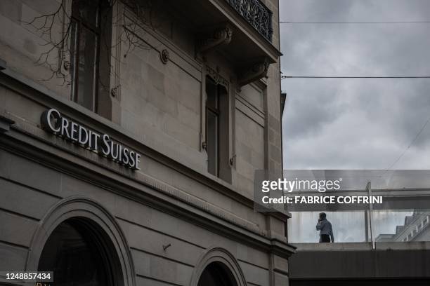 Person talks on the phone at the Credit Suisse bank headquarters in Zurich on March 20, 2023. - UBS agreed to take over Credit Suisse for $3 billion...