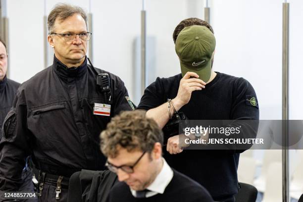 Defendant Rabieh R. Is led in handcuffs by judicial officers into the courtroom of the Higher Regional Court in Dresden, eastern Germany on March 20,...