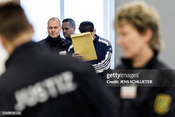 Defendant Abdul Majed R. Is led in handcuffs by judicial officers into the courtroom of the Higher Regional Court in Dresden, eastern Germany on...