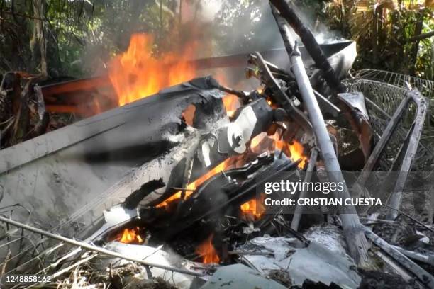 This frame grab taken from AFPTV shows fire burning parts of a military helicopter after crashing in Choco, northwestern Colombia, on March 19, 2023....