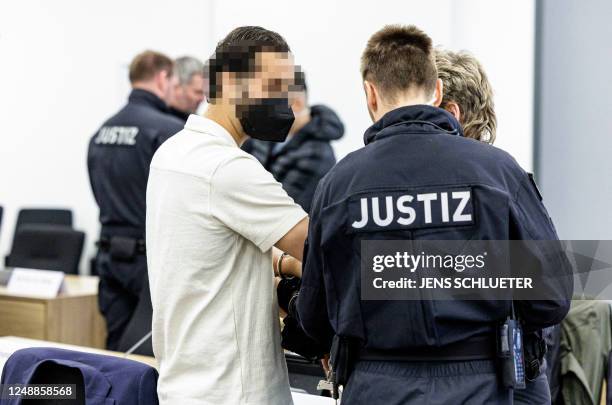 Defendant Bashir R. Is led by judicial officers into the courtroom of the Higher Regional Court in Dresden, eastern Germany on March 20, 2023 prior...