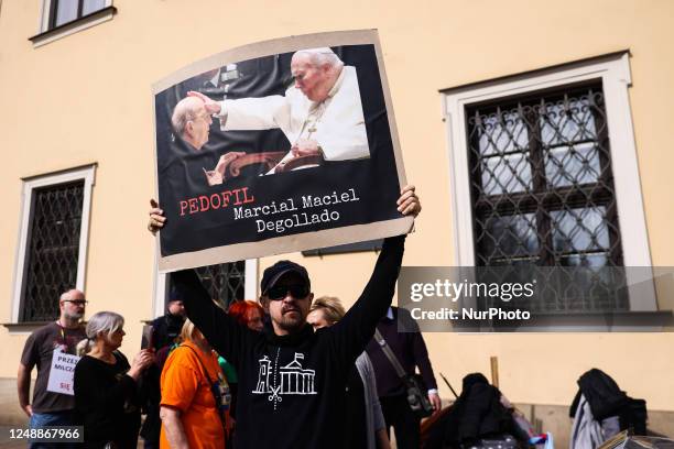 Protester holds a banner demonstrating next to the Bishops' Palace against the members of Polish catholic church hierarchy, including Polish pope...