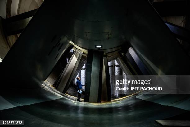 An employee of the French aeronautics, space and defense research lab examines a turbine in a wind tunnel at Modane-Avrieux ONERA's center in Modane,...