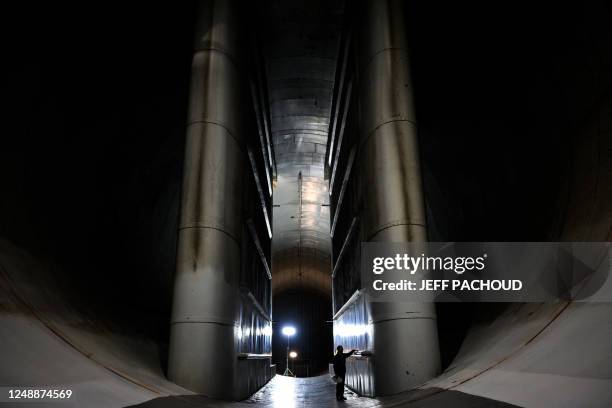 An employee of the French aeronautics, space and defense research lab walks in a wind tunnel at Modane-Avrieux ONERA's center in Modane, on March 17,...