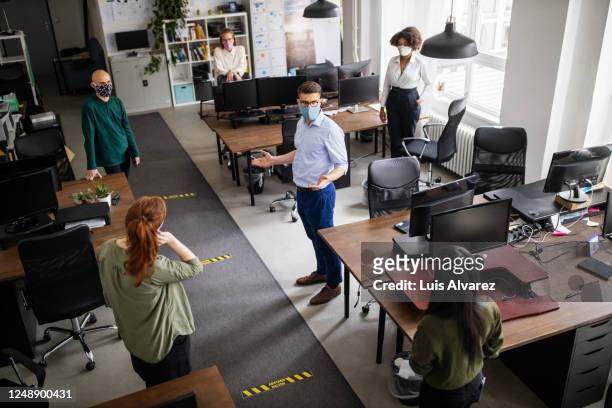 staff meeting in office with social distancing - social distancing stock pictures, royalty-free photos & images