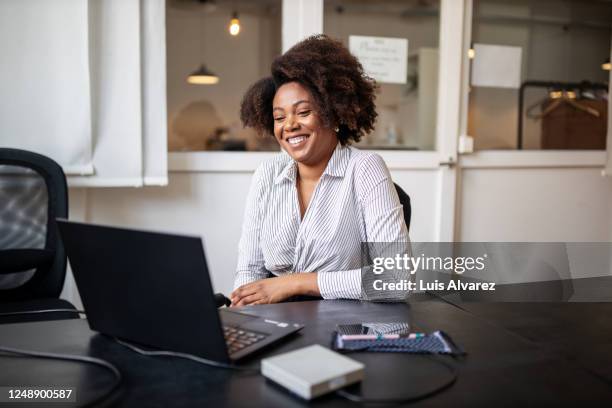 businessman sitting in office smiling during a video call - video conference stock-fotos und bilder