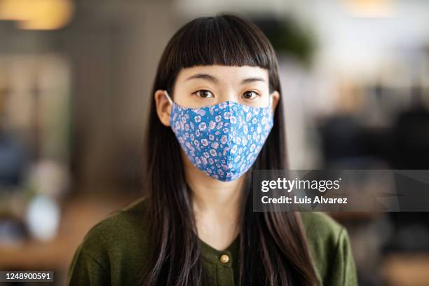 businesswoman with face mask after returning back to work at office - protective face mask stock pictures, royalty-free photos & images