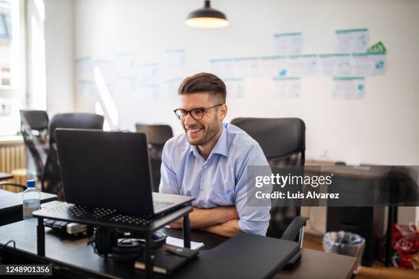 businessman on a video conference meeting - happy businessman working at his office with laptop stock pictures, royalty-free photos & images