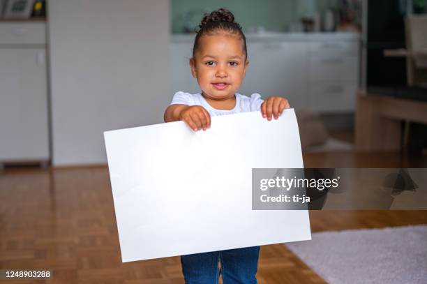 little girl holding white blank poster - child holding sign imagens e fotografias de stock