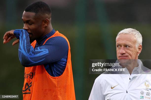 France's head coach Didier Deschamps grimaces as he looks on during a training session in Clairefontaine-en-Yvelines on March 20, 2023 as part of the...