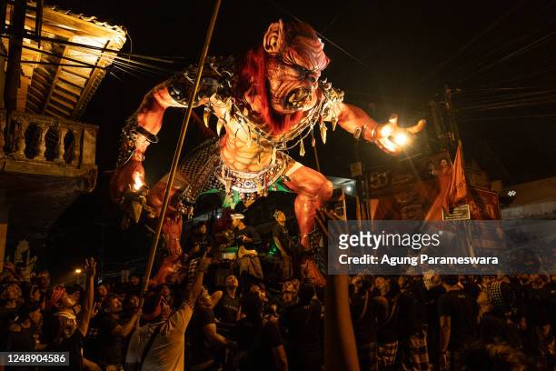 Balinese young men carry the ogoh-ogoh, the giant menacing-looking dolls during the ogoh-ogoh parade on the eve of Nyepi, the Balinese Hindu Day of...