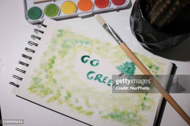 'Go Green' is painted on a drawing book in Athens, Greece on March 20, 2023.