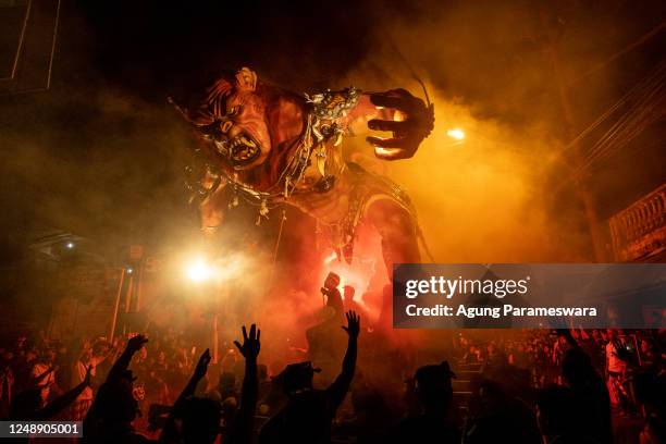 Balinese young men carry the ogoh-ogoh, the giant menacing-looking dolls during the ogoh-ogoh parade on the eve of Nyepi, the Balinese Hindu Day of...