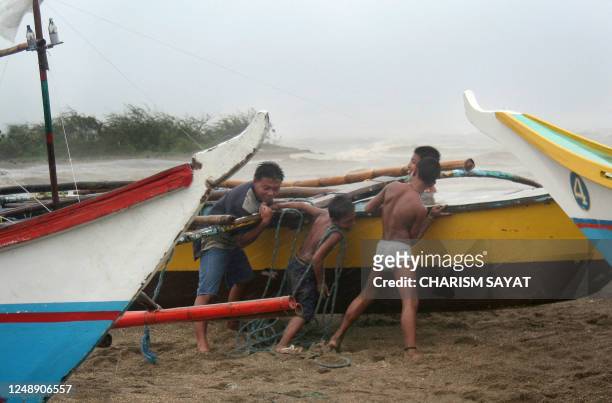 Fisherman pull their boats to safety from big waves battering Bulan in Sorsogon province located in the southern tip of the main Philippine island of...