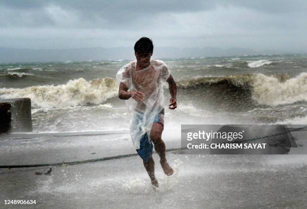 Fisherman runs from big waves after securing his boat at a fish port in Bulan in Sorsogon province located in the southern tip of the main Philippine...
