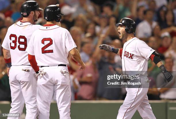 Dustin Pedroia of the Boston Red Sox reacts after he hit a three-run home run with teammates Jarrod Saltalamacchia of the Boston Red Sox and Jacoby...