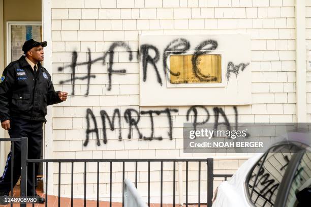 Security guard stands watch at the Indian Consulate as a graffitti behind him reads "FreeAmritpal" in San Francisco, California on March 20, 2023. -...