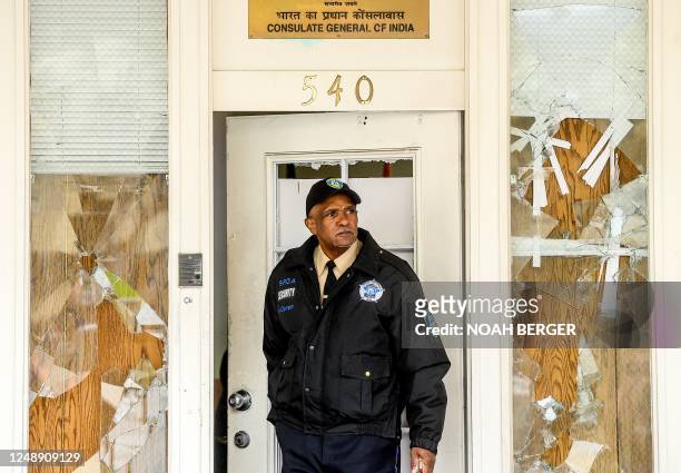 Security guard stands watch at the Indian Consulate as broken windows are seen behind him, in San Francisco, California on March 20, 2023. - Indian...