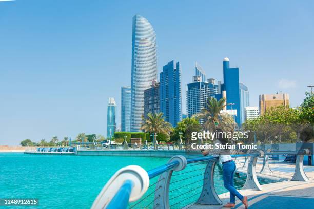 female tourist visiting abu dhabi downtown corniche area and enjoying the view - abu dhabi stock pictures, royalty-free photos & images